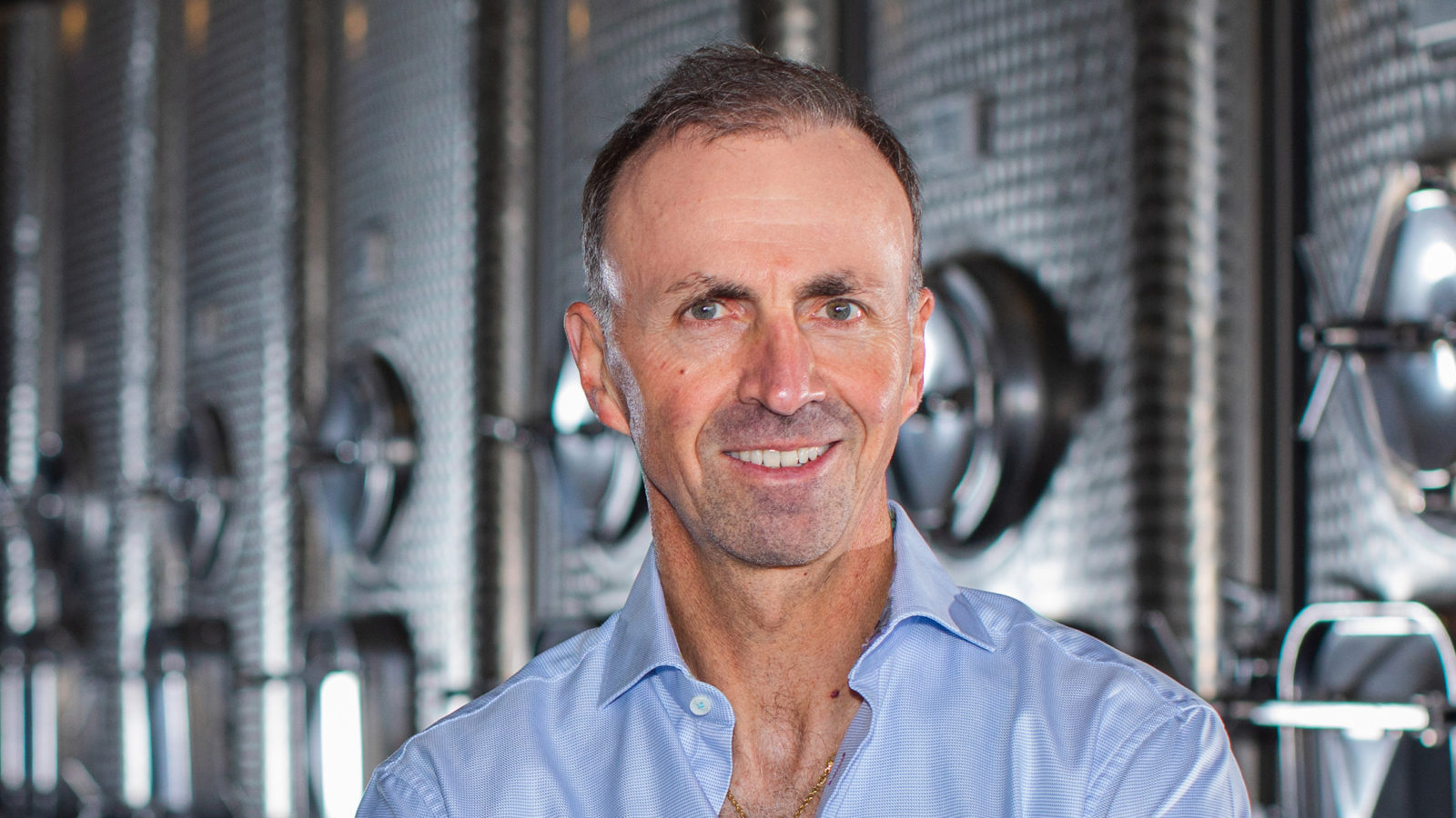 René Schlatter standing in front of fermentation tanks